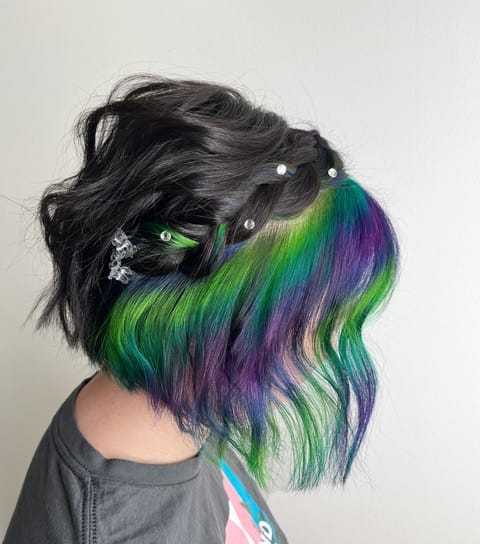 Woman with colorful rainbow hair and decorative hair clips.