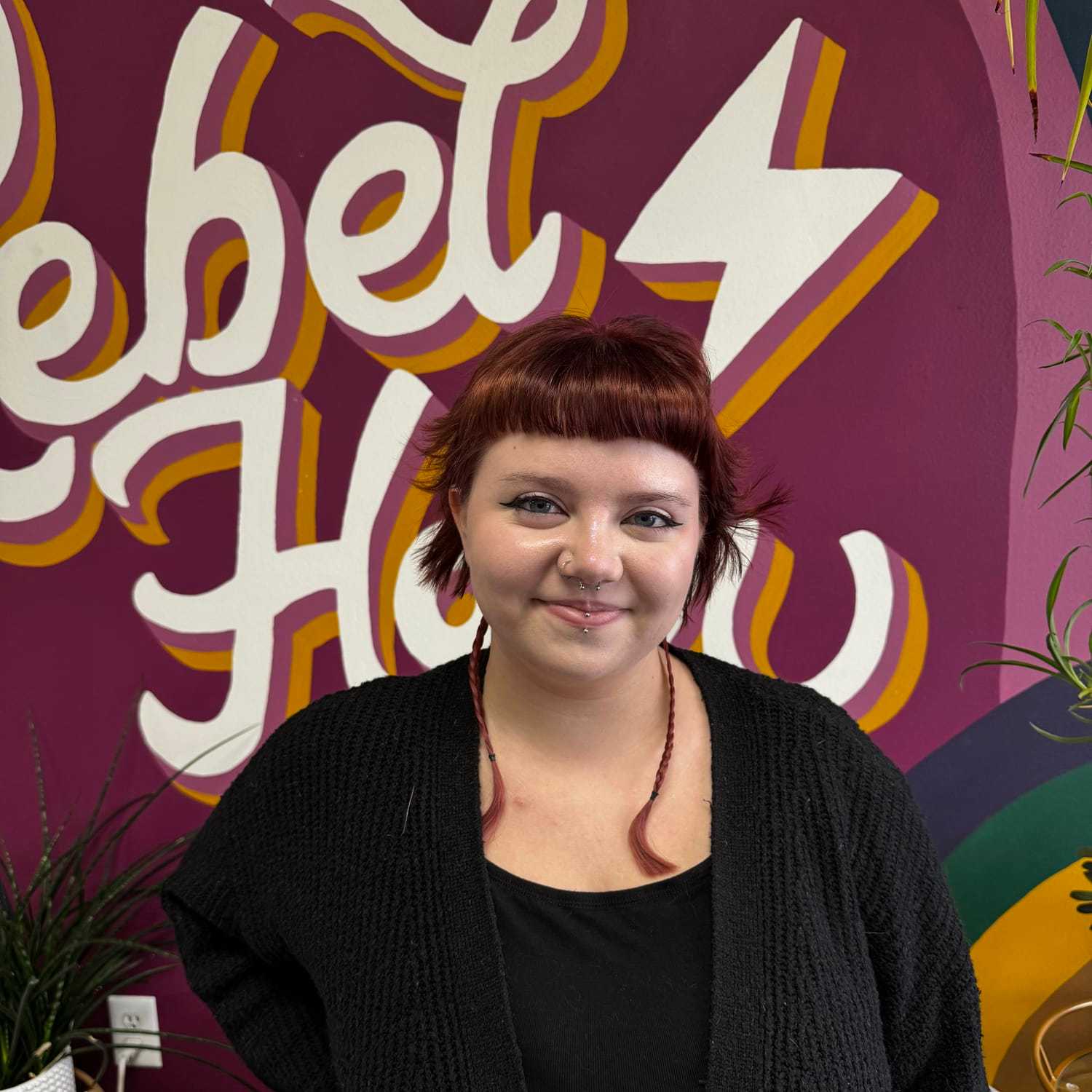 Portrait of Charlie (She/They), a professional stylist at Rebel Hair, showcasing their expertise and style.