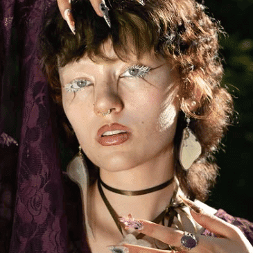 Portrait of Atlas (They/Them), a professional stylist at Rebel Hair, showcasing their expertise and style.